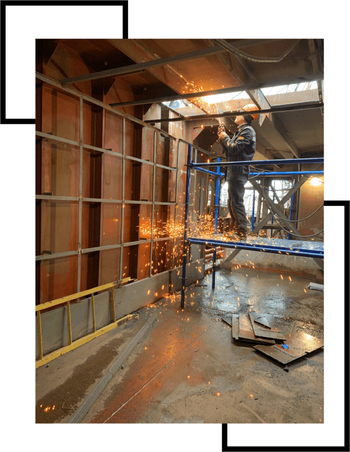 A man standing on a scaffold in the middle of a room.