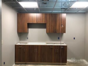 A kitchen with wooden cabinets and white counters.