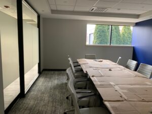 A long table with chairs in front of a window.