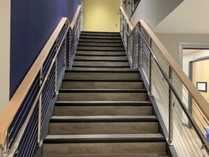 A staircase with metal railing and wood steps.