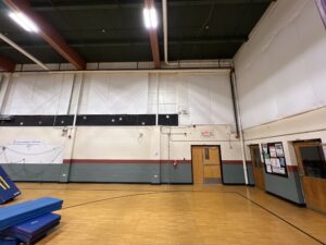 School gym with wood floor and basketball hoops.