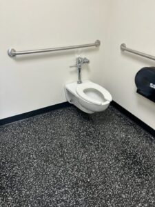 Toilet and grab bars in a public restroom.