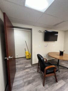 A conference room with a TV and a round table.