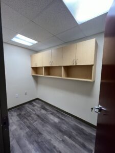 Empty office room with cabinets on wall.