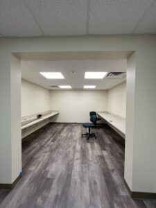 An empty room with a chair and two desks.