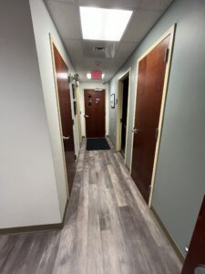 A hallway with brown doors on both sides.